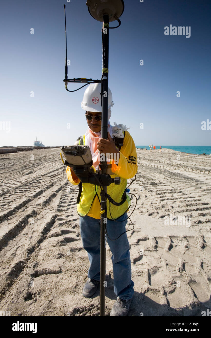 Asiatische Landvermesser, die Durchführung von Messungen an einem Projekt der Landgewinnung in Dubai Stockfoto