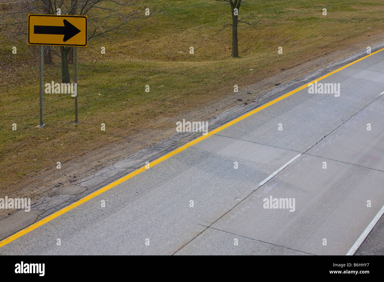 Ein gelber Zug-Zeichen auf der Seite der Autobahn nähert sich eine scharfe drehen Stockfoto