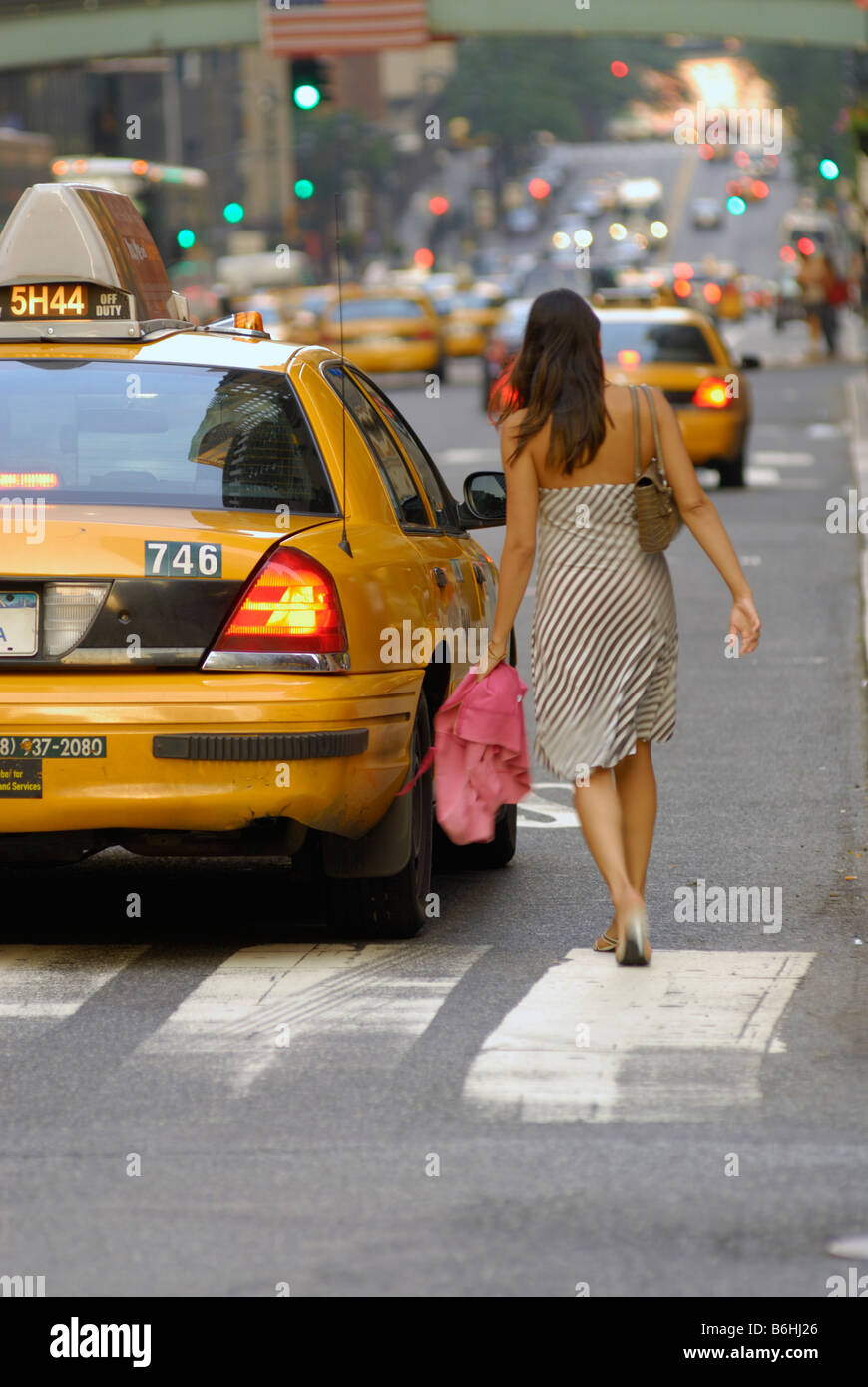 Junge Dame fangen ein gelbes Taxi in New York City, Vereinigte Staaten von Amerika Stockfoto