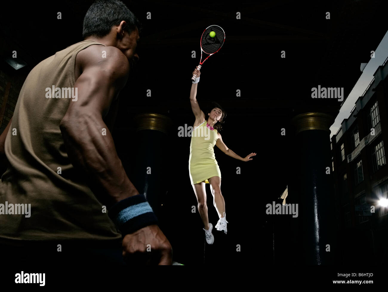 Männliche und weibliche Tennis spielen in der Nacht, in der Stadt, Stimmung, Sonne, aber immer noch daran interessiert, zu spielen und wettbewerbsfähig sein Stockfoto