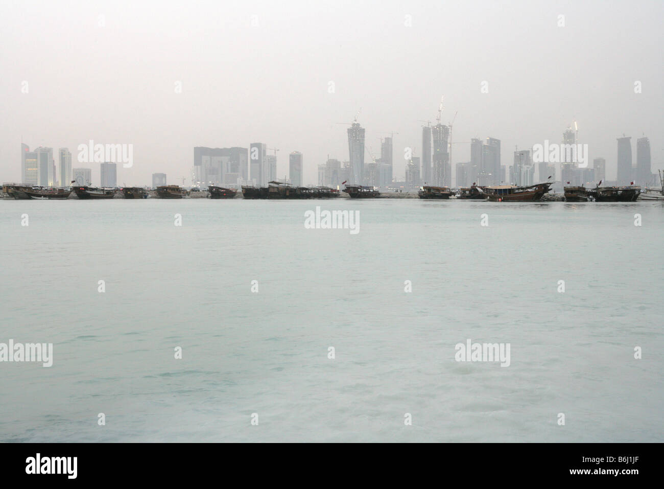 Sicht auf die Skyline von Doha und Reihe der Boote von der Bucht, Katar, Naher Osten Stockfoto