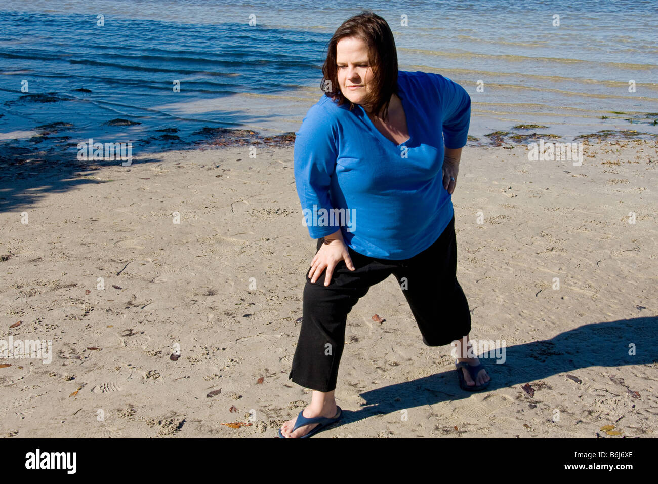 Schöne Plus size Frau Training am Strand Stockfoto
