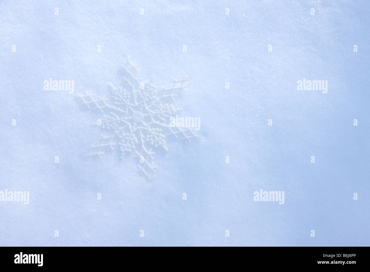 Schneeflocke Ornament Verlegung in frischen weißen Winterschnee Stockfoto