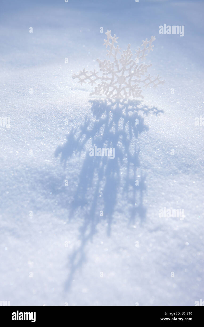Schneeflocke Ornament Guss Schatten auf dem weißen Winterschnee Stockfoto