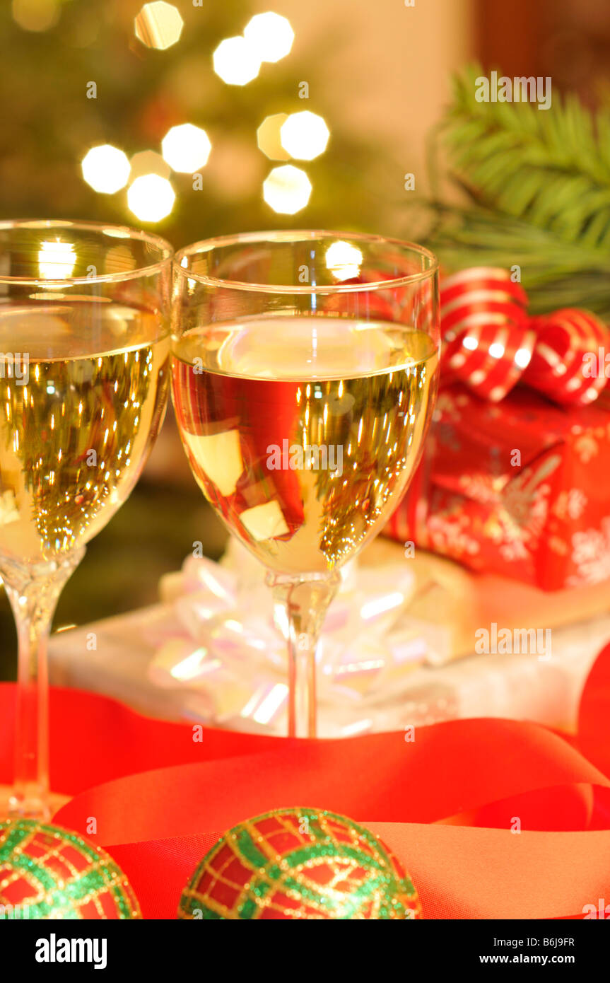 Weihnachten Konzept gefüllten Weingläser auf Tabelle mit Weihnachtsschmuck und präsentiert mit beleuchtetem Baum im Hintergrund. Stockfoto