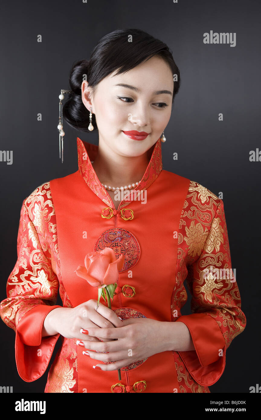 Junge Frauen im Cheongsam hält eine rose Stockfoto