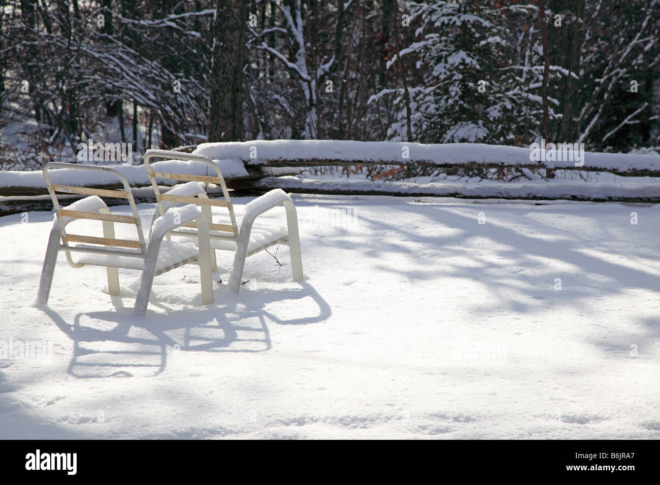 Sommer-Lounge-Sessel Links auf Schnee, jetzt dramatisch in die langen Schatten der späten Nachmittag & Winter Schneedecke im Dezember warten Stockfoto