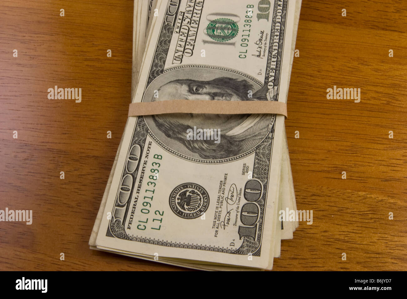 US $100 Dollarnoten auf Holztisch Stockfoto