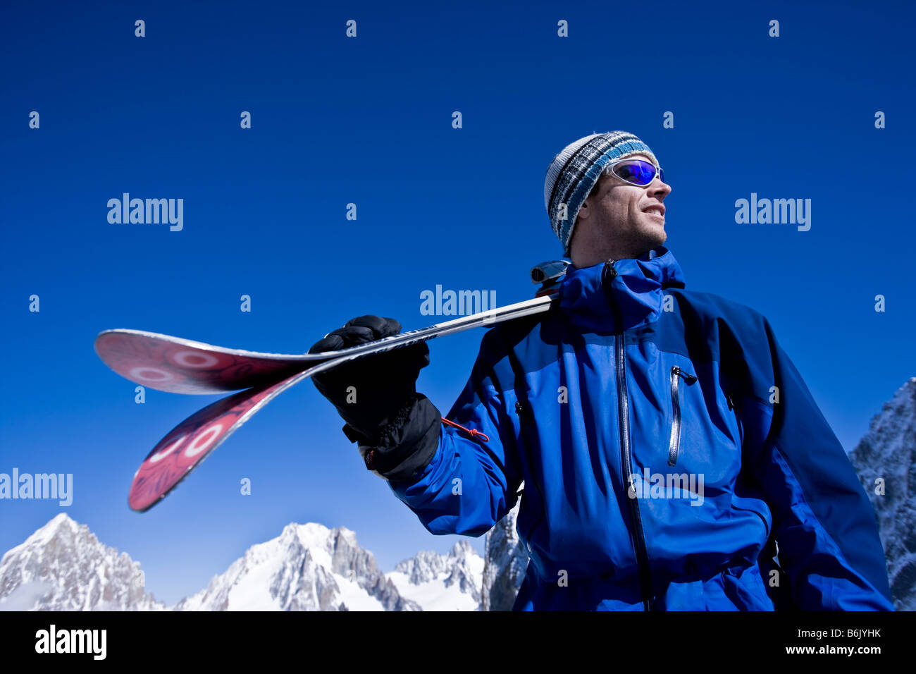 Frankreich, Chamonix, Grands Montets. Ein Mann hält Skier an der Spitze eines Aufzugs Stockfoto