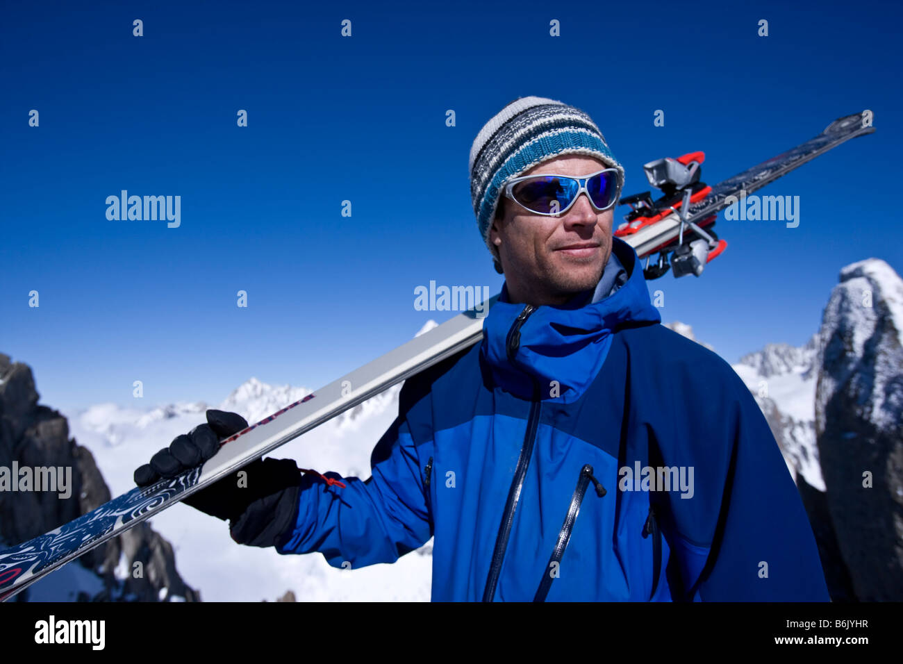 Frankreich, Chamonix, Aiguille Verte. Ein Mann hält Skier an der Spitze eines Aufzugs Stockfoto