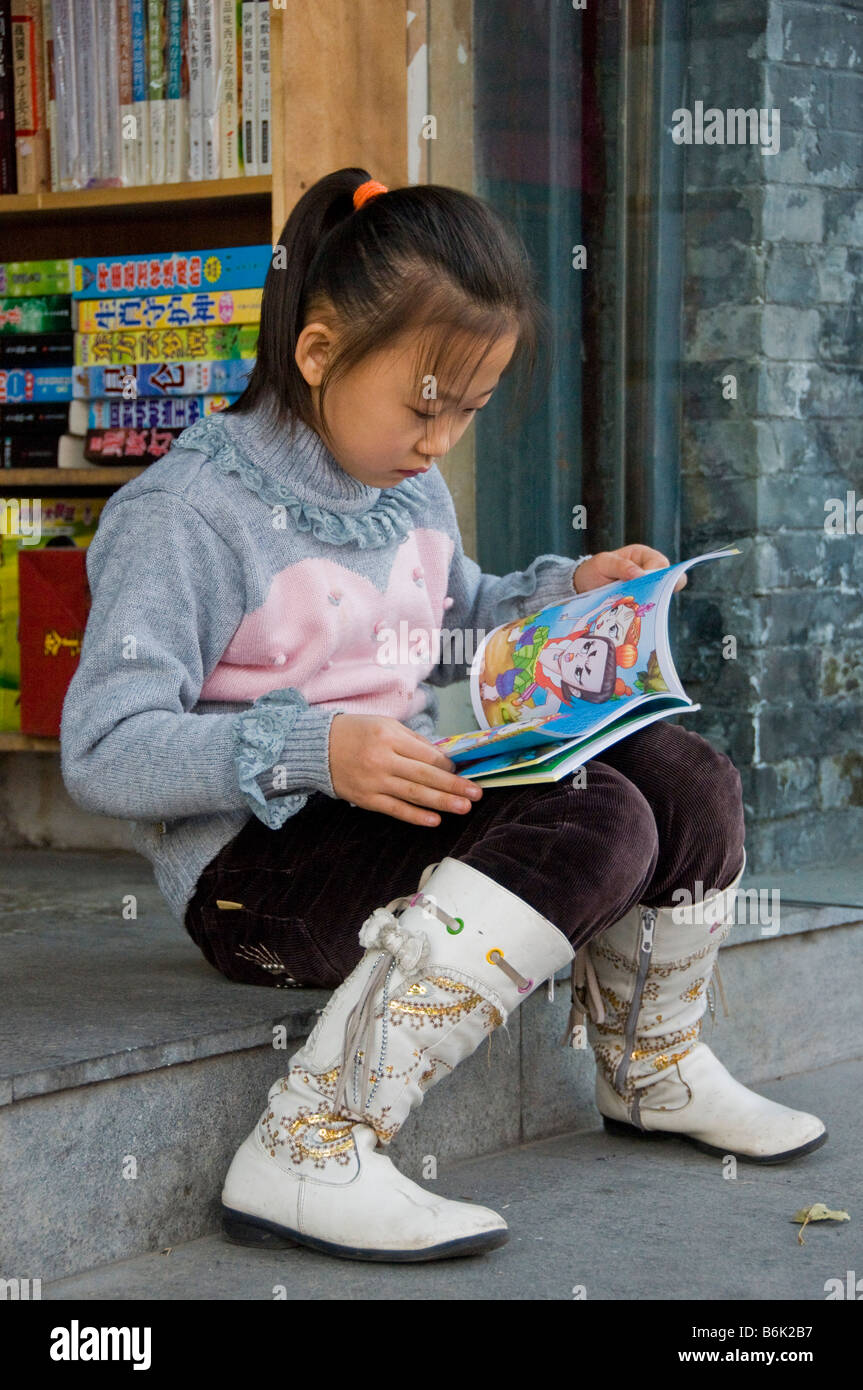 Mädchen lesen ein Buch vor einer Buchhandlung Peking China Stockfoto