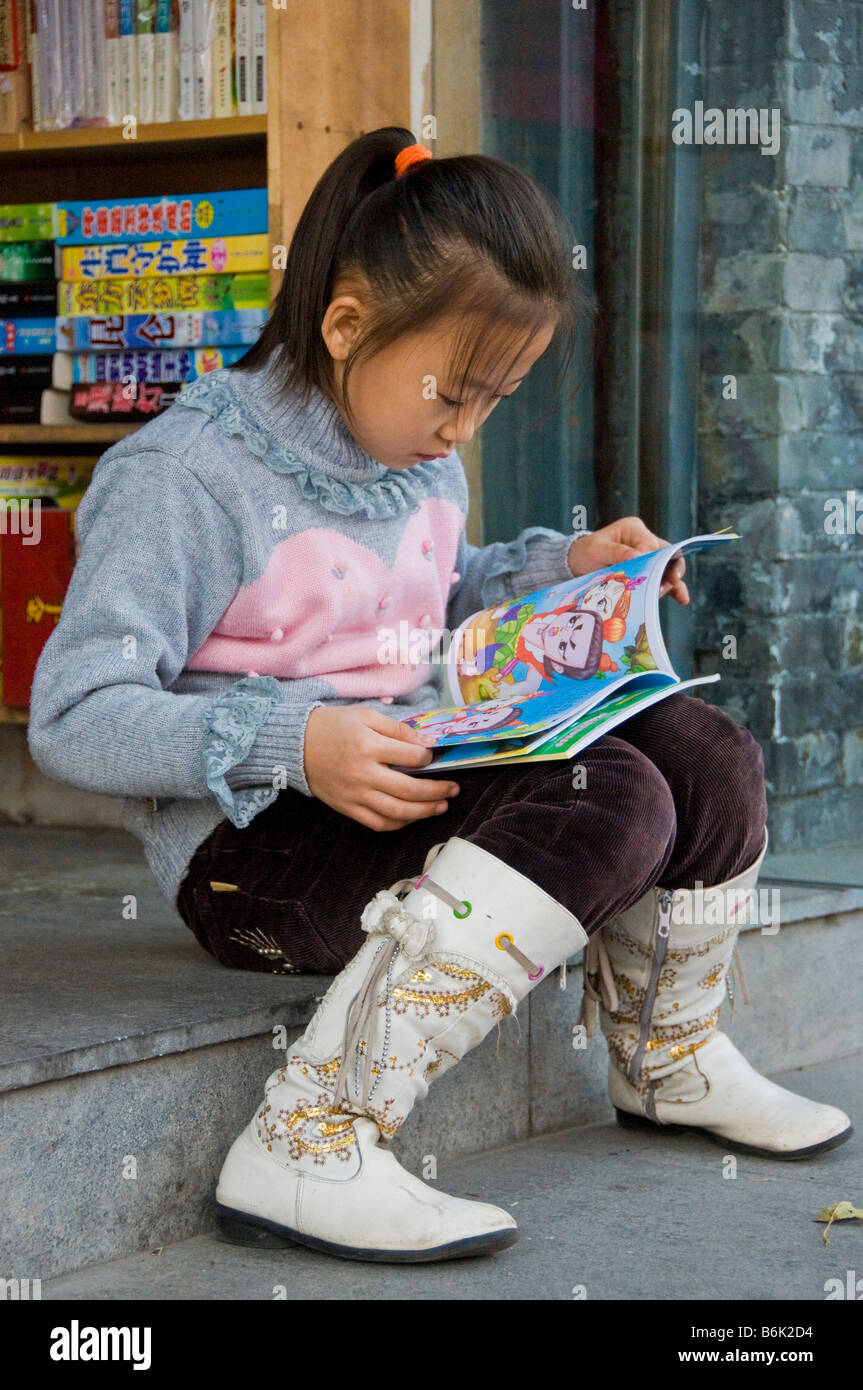 Mädchen lesen ein Buch vor einer Buchhandlung Peking China Stockfoto
