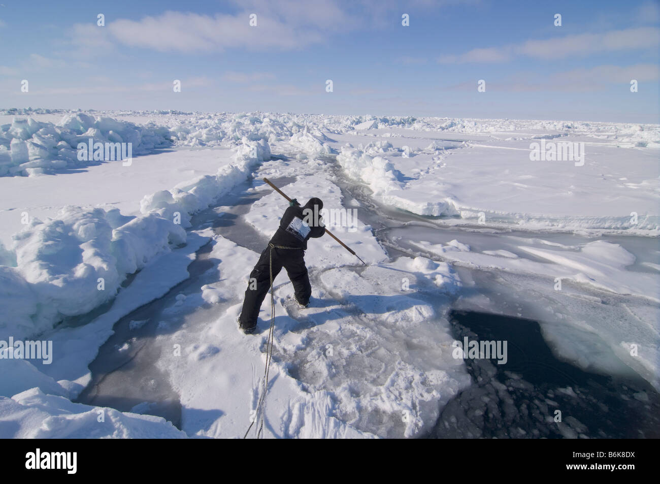 Inupiaq Subsistenz Jäger öffnet ein Loch in das Packeis für potentielle Tierwelt Tschuktschensee passieren Stockfoto