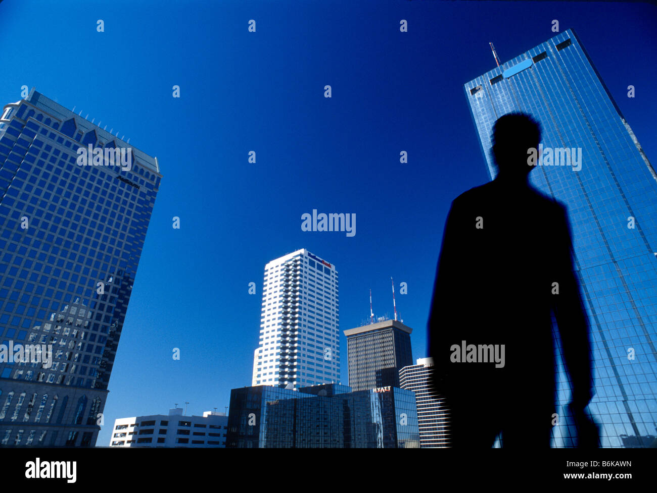 Geschäftsmann mit Aktenkoffer zu Fuß unter hohen modernen Bürogebäuden Stockfoto