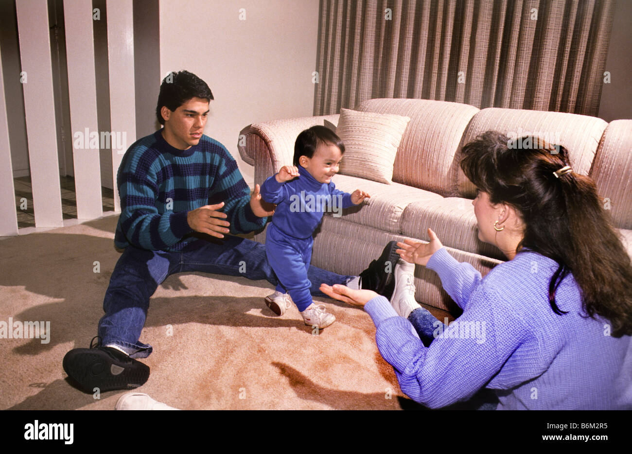 Hispanische Eltern Spaß zu sehen, ihr Sohn seine ersten Schritte. Stockfoto