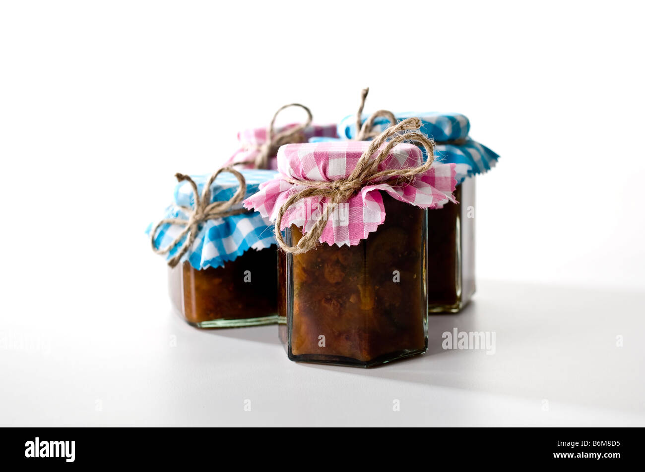 Gläser Chutney in ziemlich kariertem Stoff mit rustikalen Bindfaden abgedeckt. Als Geschenke gegeben werden. Stockfoto