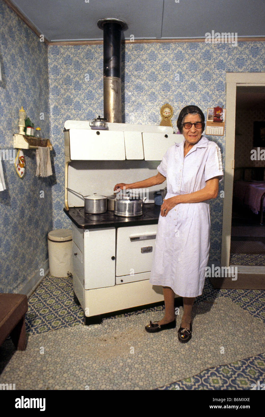 USA NEW MEXICO LINCOLN kocht eine ältere Hispanic Frau an ihrem alten Holzofen in ihrem Haus in Lincoln, New Mexico Stockfoto