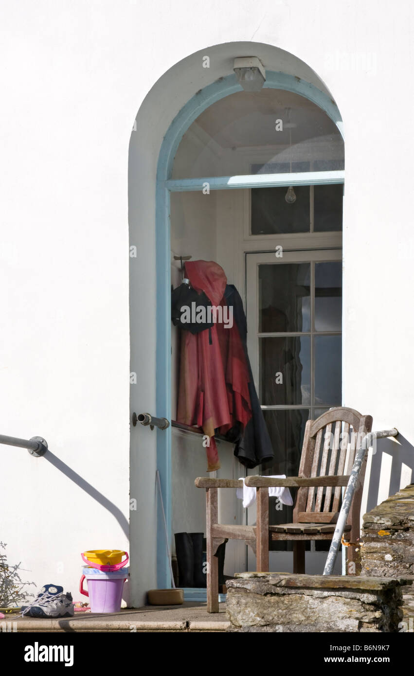 Souwesters und ein Regenschirm hängen auf der Veranda eines Hauses in St. Mawes, Roseland, Cornwall Stockfoto