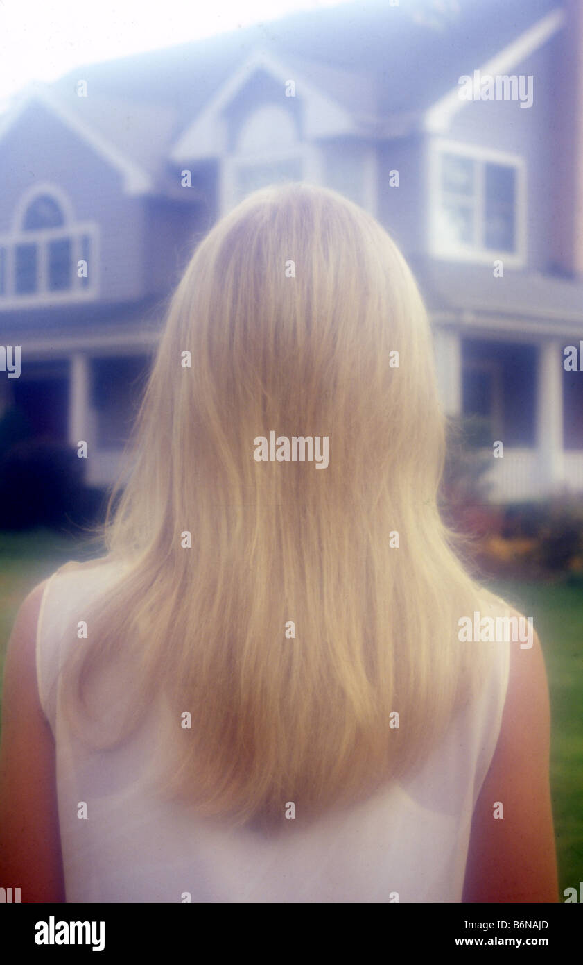 blonde Frau von hinten mit Haus im Hintergrund Stockfoto