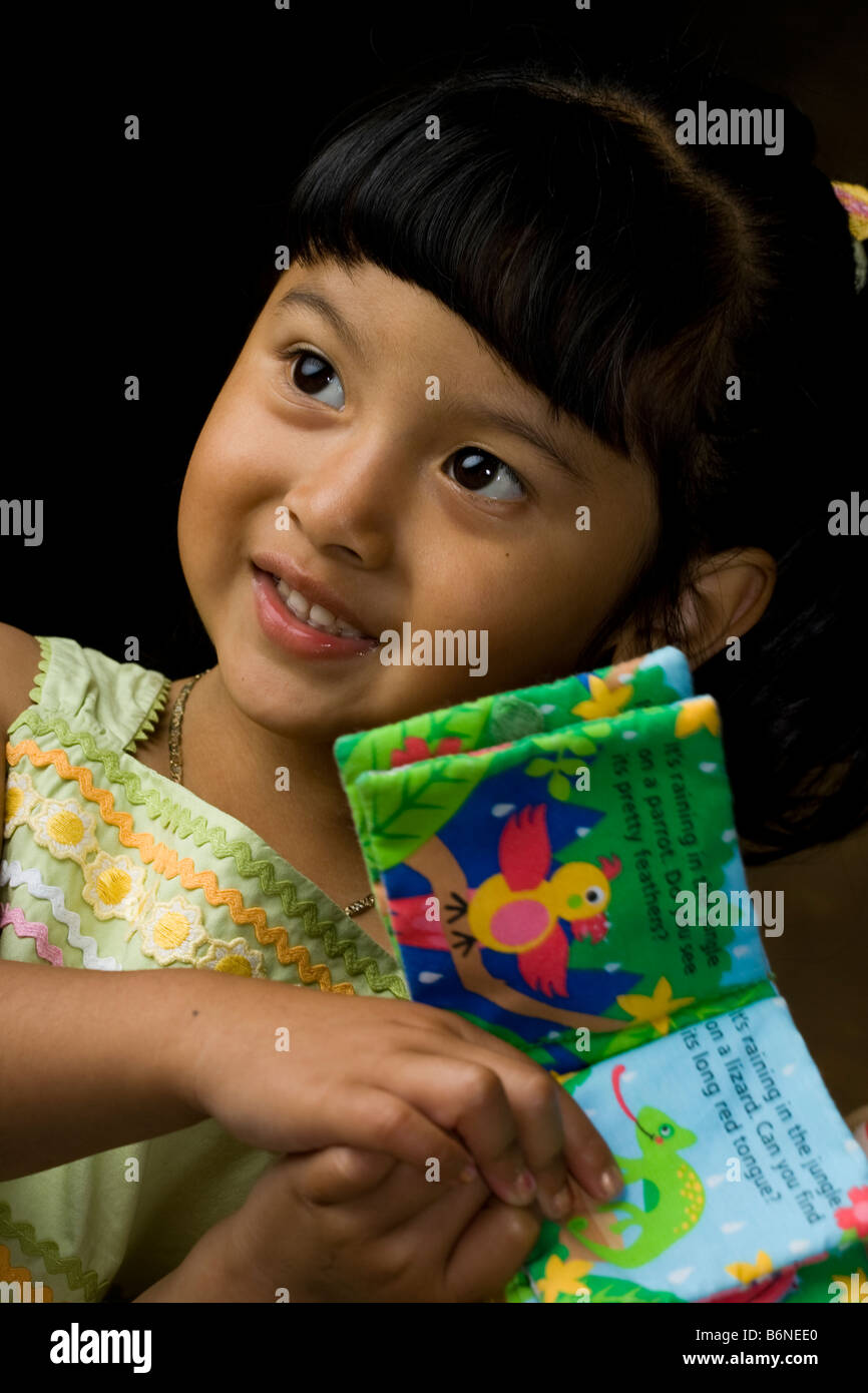 Hispanischen Mädchen hält ein Spielzeug-Buch Stockfoto