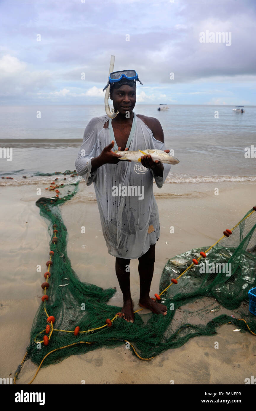 EIN HANDWERKER FISCHER MIT EINEM FANG VON NETZEN AM STRAND IM MORGAN BAY RESORT IN DER NÄHE VON CASTRIES, ST. LUCIA Stockfoto