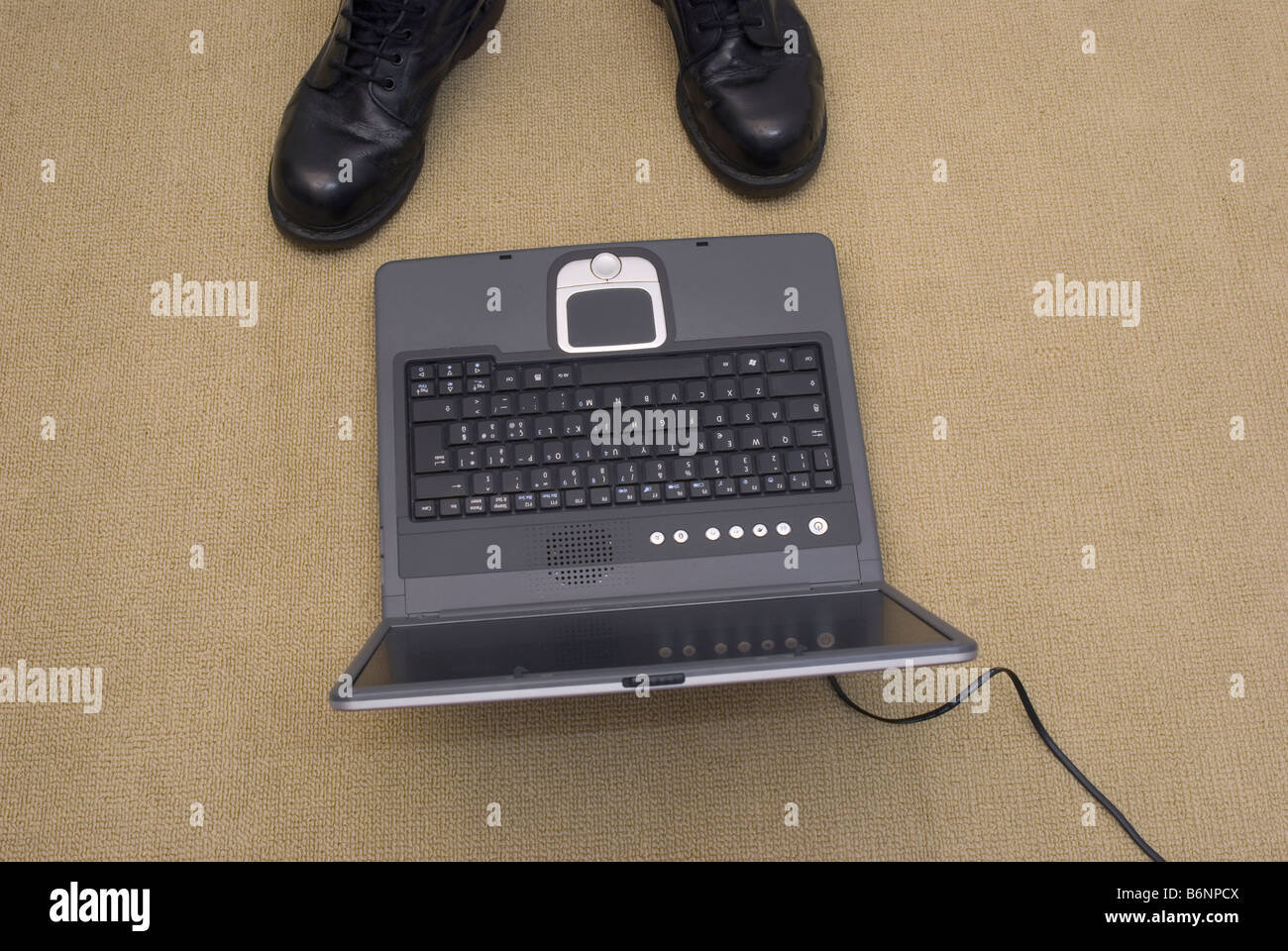 nach unten gerichtete Blick auf Notebook auf dem Boden und ein paar Stiefel Stockfoto