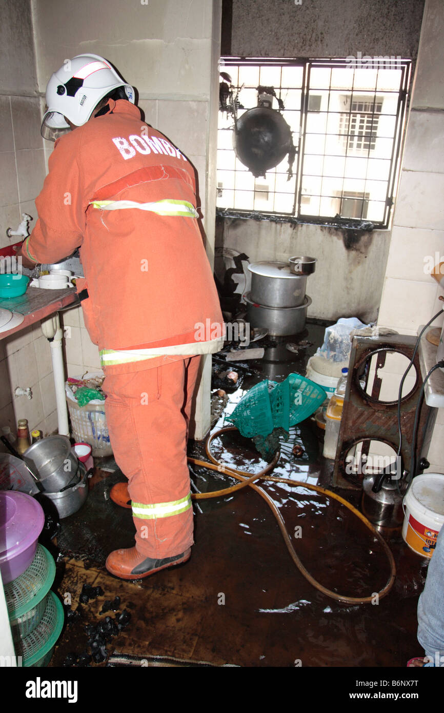 Ein Feuerwehrmann Inspektion eine Küche, die durch einen Brand zerstört. Stockfoto
