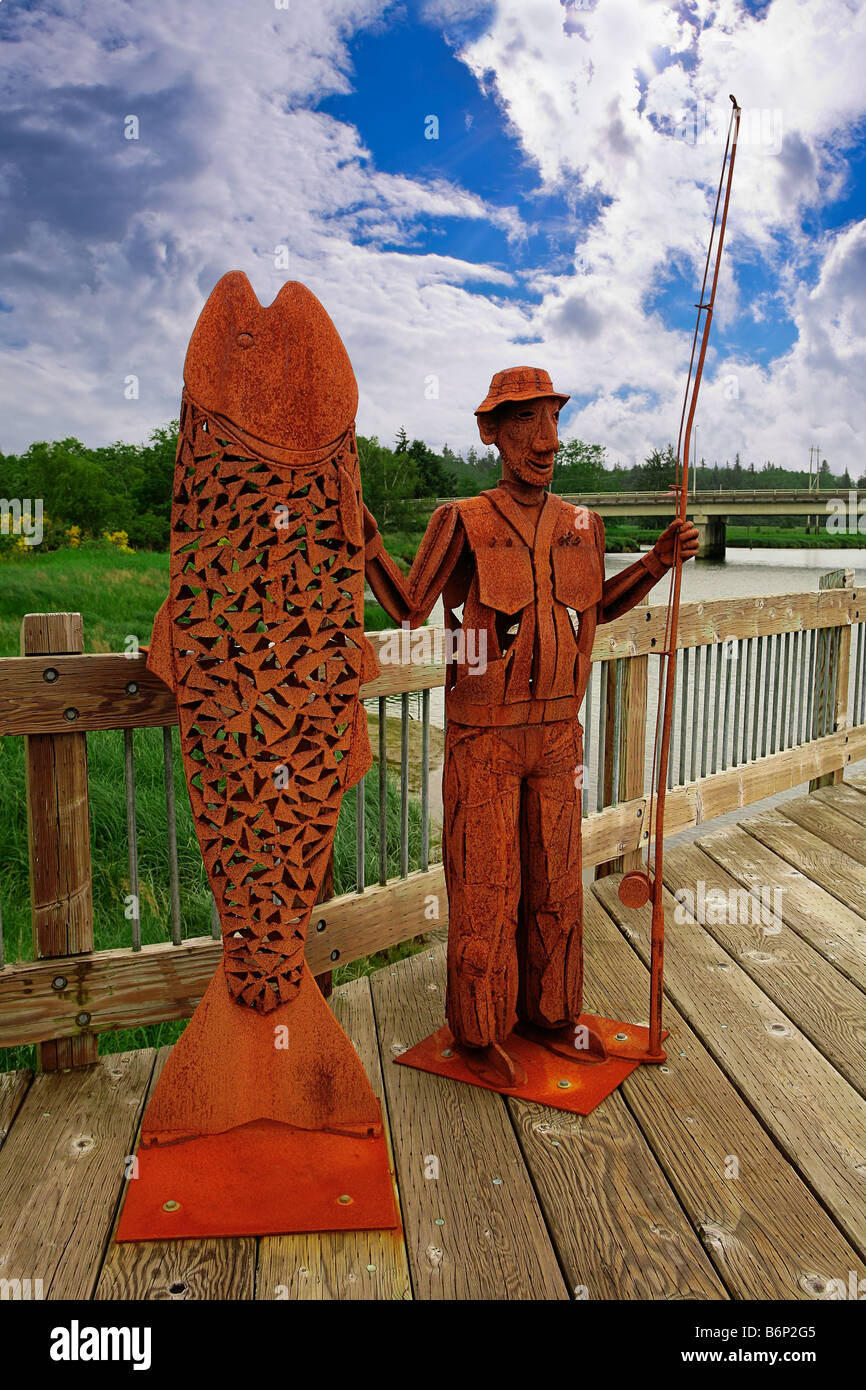 Bild einer Metall Ausschnitt Skulptur zeigt einen Lifesize-Mann, der seine Pole Position und ein riesiger Fisch Stockfoto