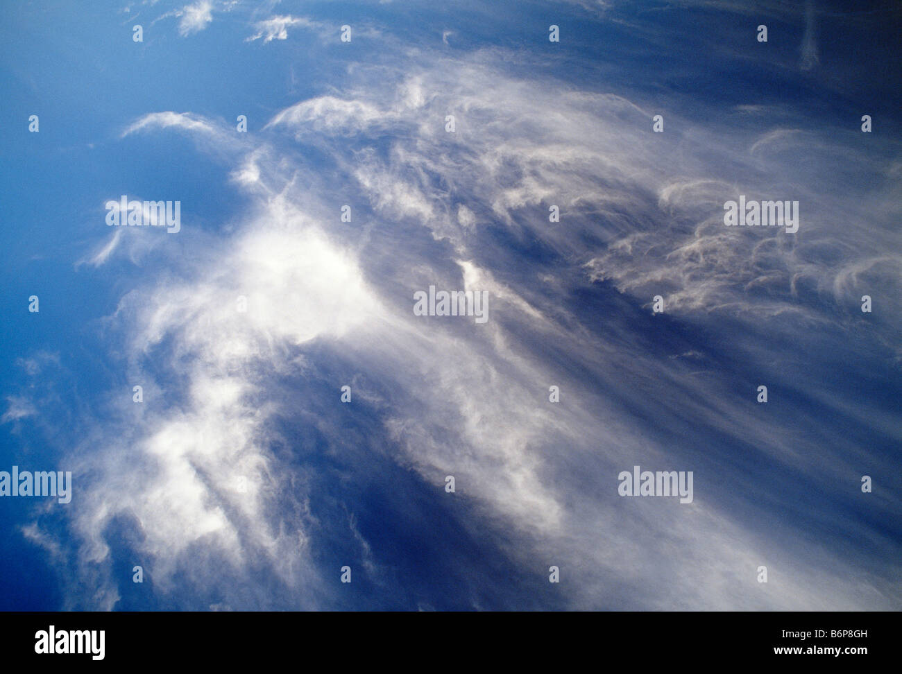 Dramatische weiße Wolkenfetzen vor blauem Himmel Stockfoto