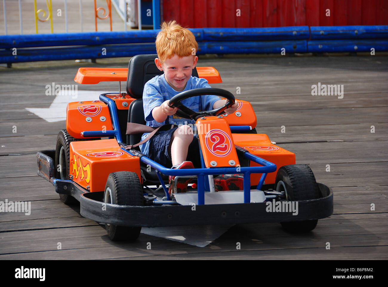 Ginger Rothaarige Kind in Elektro-Rennwagen auf Kirmes Stockfoto