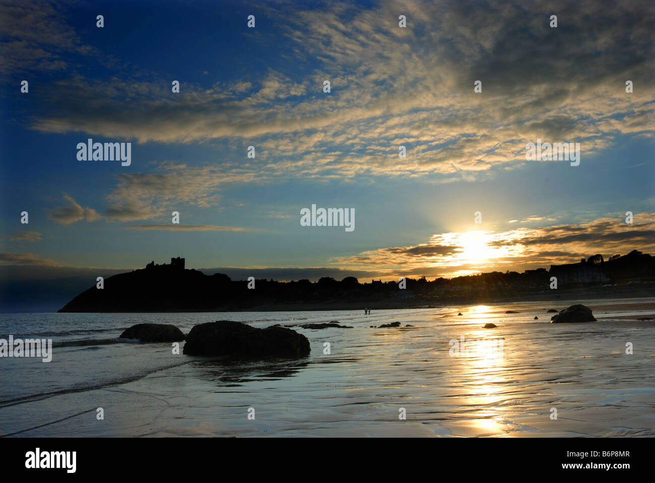 Sonnenuntergang an der walisischen Küste in Criccieth, mit Schloss im Hintergrund Stockfoto