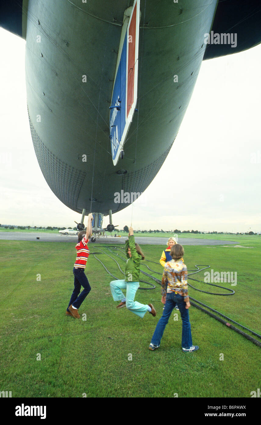 Kinder spielen mit Seilen unter Goodyear Blimp vor dem Schlafengehen für Fahrt in Handwerk, California Stockfoto