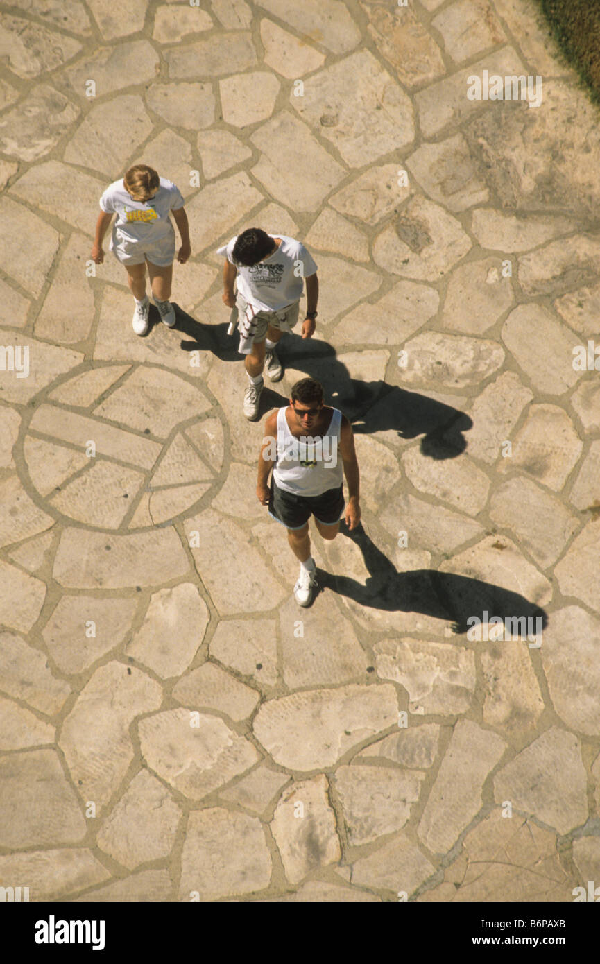 Drei Menschen anhalten auf Steinplatten Terrasse mit Einschub Kompass mark Stockfoto