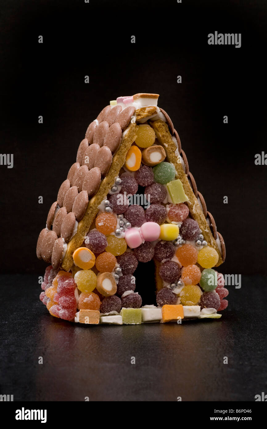 Lebkuchenhaus mit Süßigkeiten Süßigkeiten Süßwaren geflieste Wände, Schaltfläche "Schokolade" Dachziegel. Stockfoto