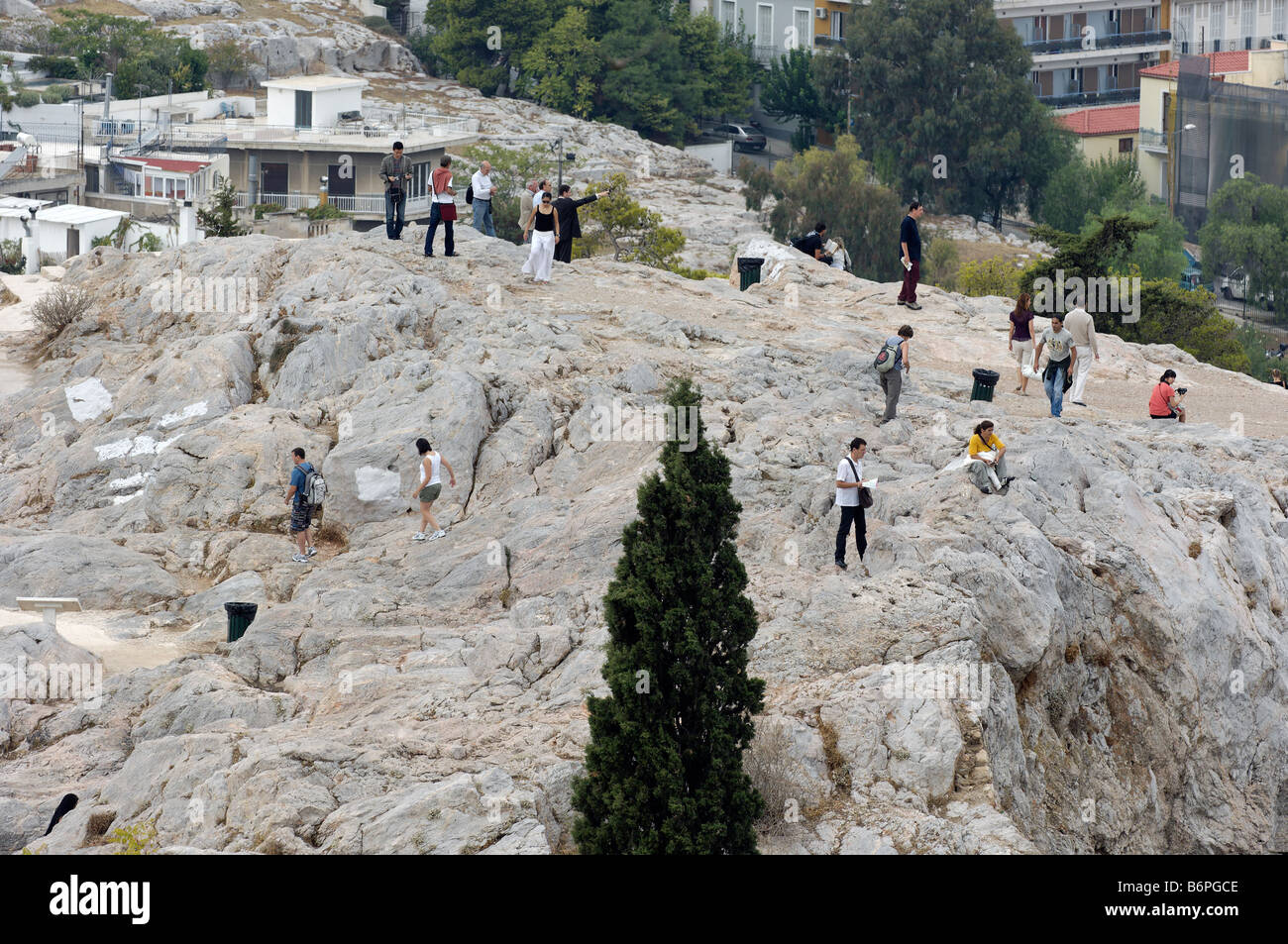 Menschen sehen aus wie Ameisen auf einem Hügel vor der Akropolis. Stockfoto