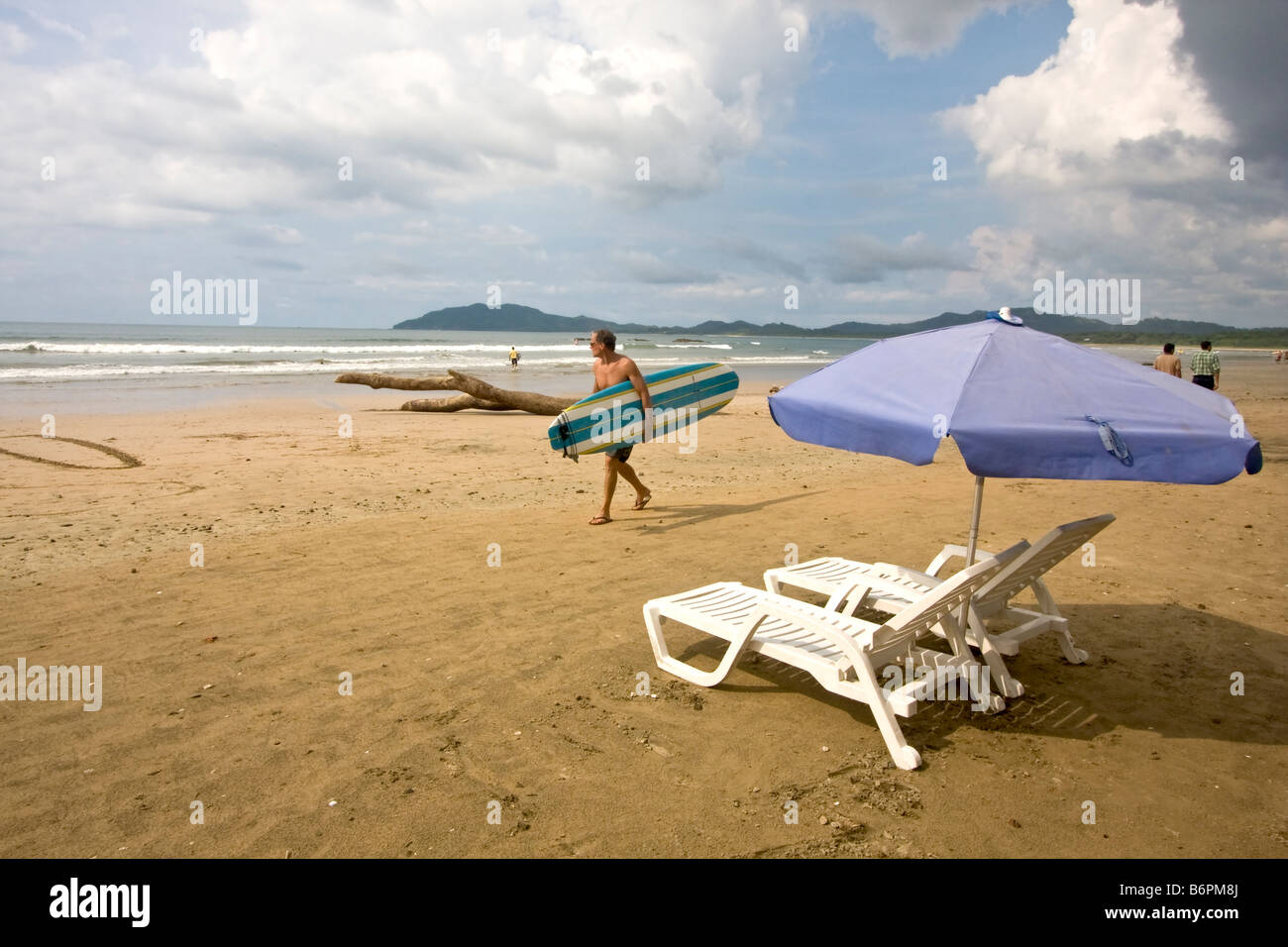 Surfer geht auf Strand in Tamarindo, Costa Rica. Costa Rica ist eine beliebte Surf-Standort geworden. Stockfoto
