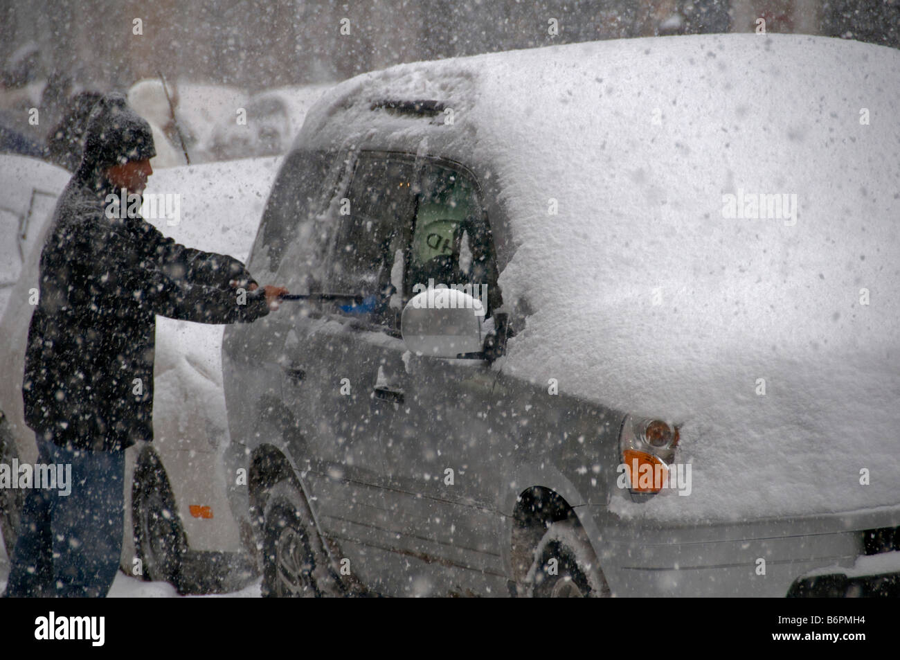Mann aus dem Auto entfernen von Schnee während eines Schneesturms Montreal Kanada Stockfoto