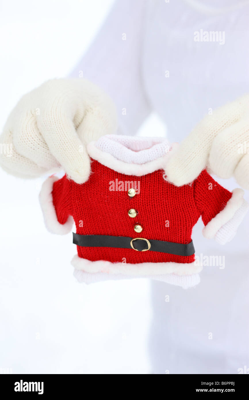 Hände mit Winterhandschuhe halten kleine Santa Claus Jacke Stockfoto