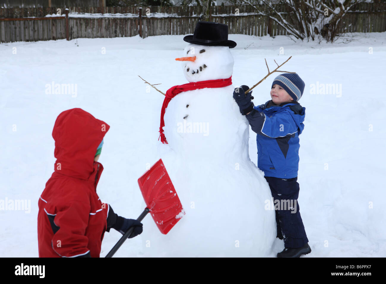 Zwei jungen Schneemann bauen Stockfoto