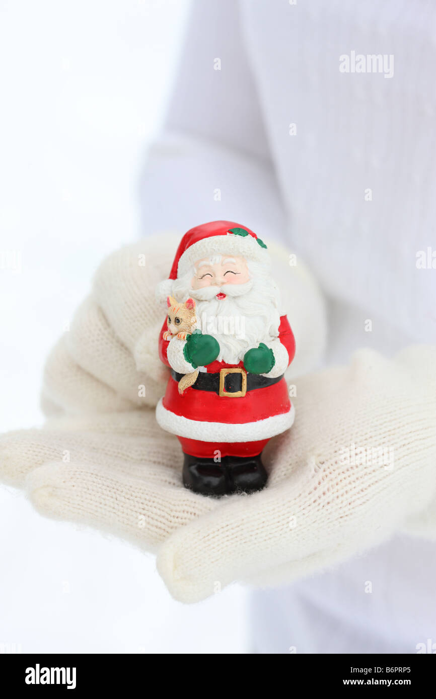 Hände mit Winterhandschuhe halten Santa Claus Weihnachten Figur Stockfoto