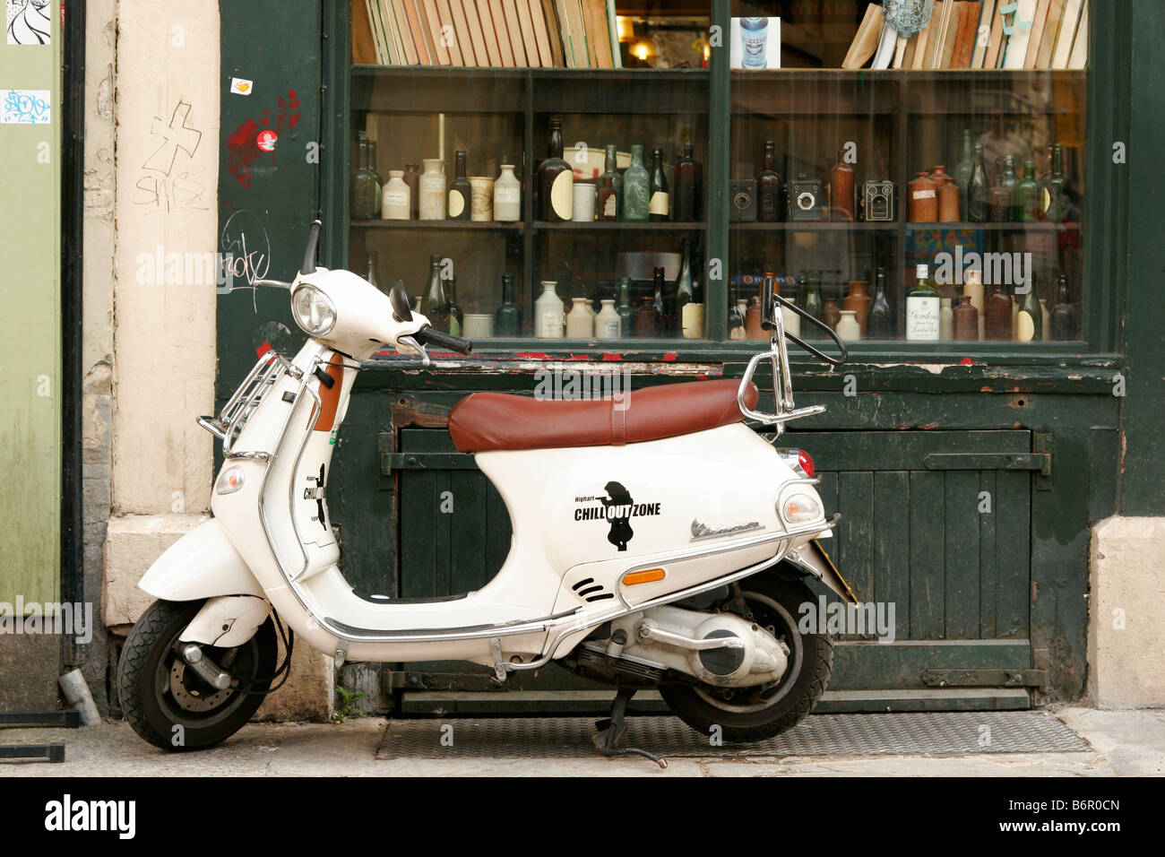 Creme-Vespa-Roller mit braunem Ledersitz, parkte vor einem Pub mit alten  Flaschen und Bücher, die im Fenster angezeigt Stockfotografie - Alamy