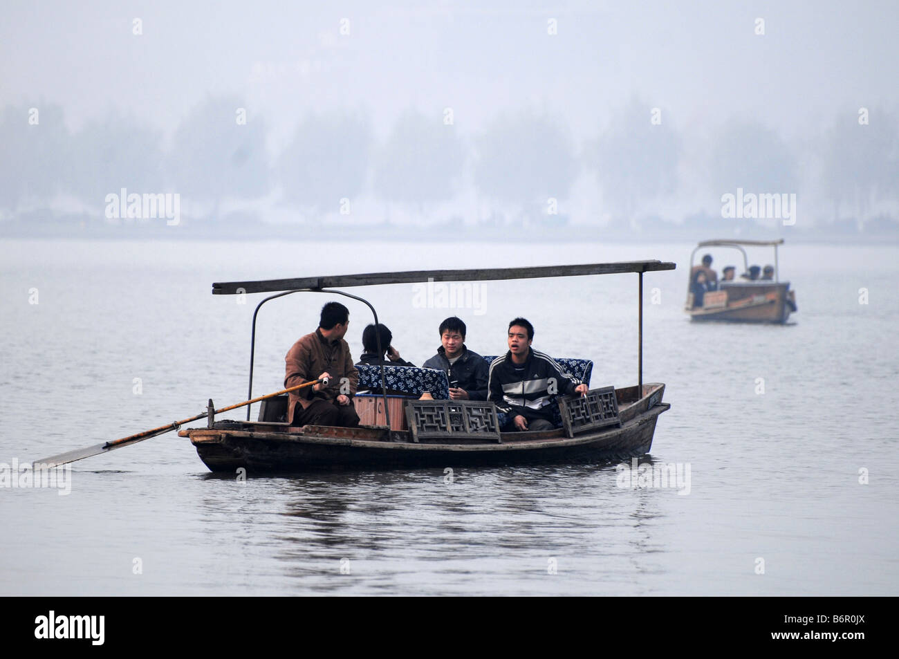 Chinesische Touristen fahren auf einem Boot in berühmten Westsee in Hangzhou im Winter, China. Stockfoto