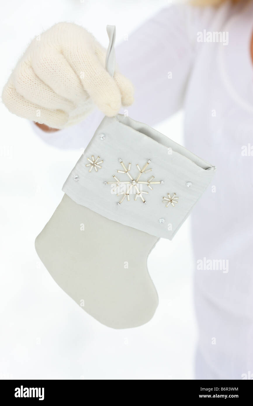 Hände mit Winterhandschuhe holding Christmas Stocking Stockfoto
