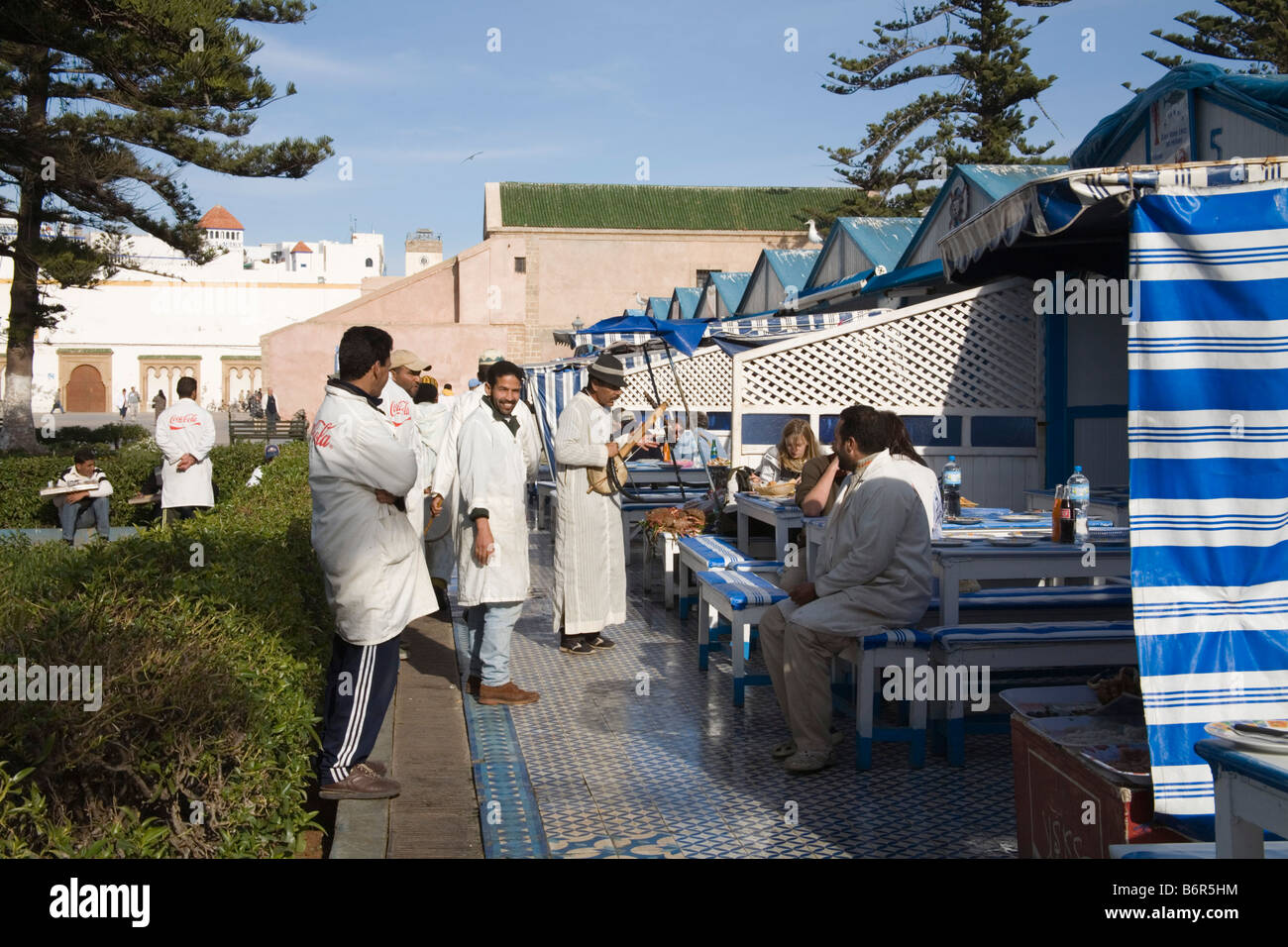 Essaouira Marokko Nordafrika Dezember Touristen Essen Fisch-Restaurants in Hauptplatz der Stadt unterhalten marokkanischer Musiker Stockfoto