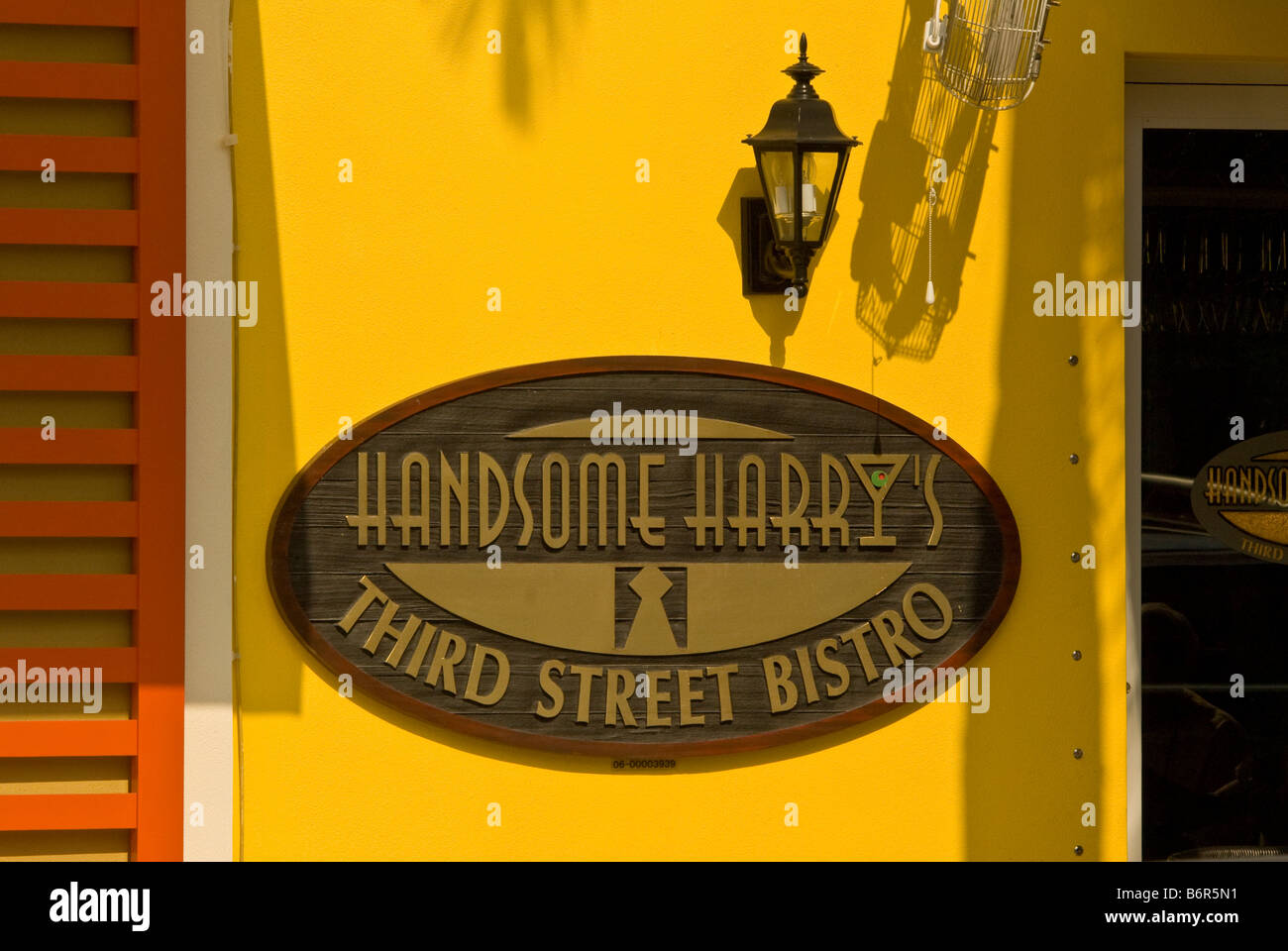 Gut aussehend Harrys dritten Street Bistro 3rd Street St Zeichen Old Naples Florida fl leuchtend gelbe Farbe Palm Baum Schatten Stockfoto