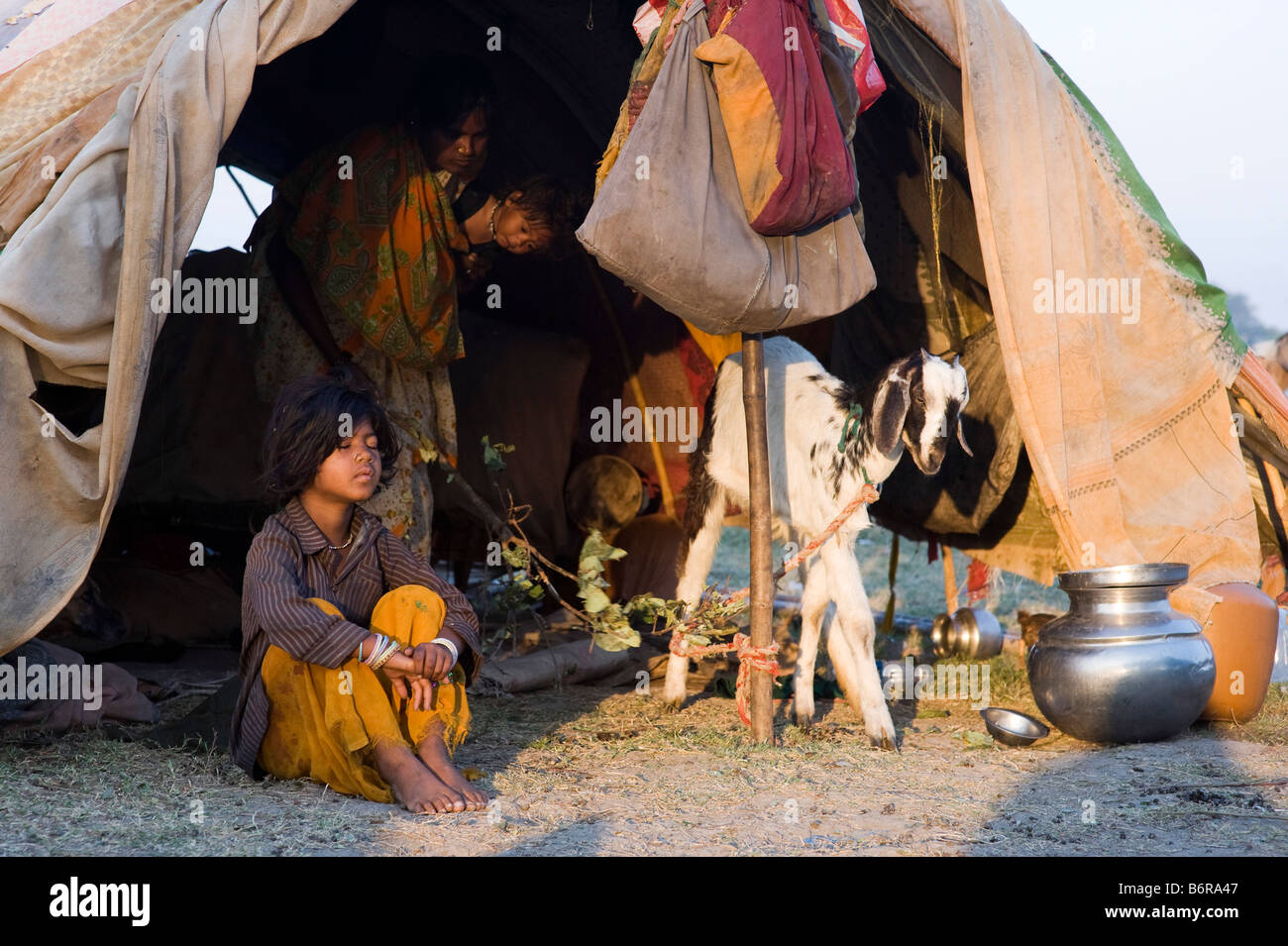 Arme nomadischen indische Mädchen sitzen in ihrem Zelt im frühen Morgenlicht. Andhra Pradesh, Indien Stockfoto