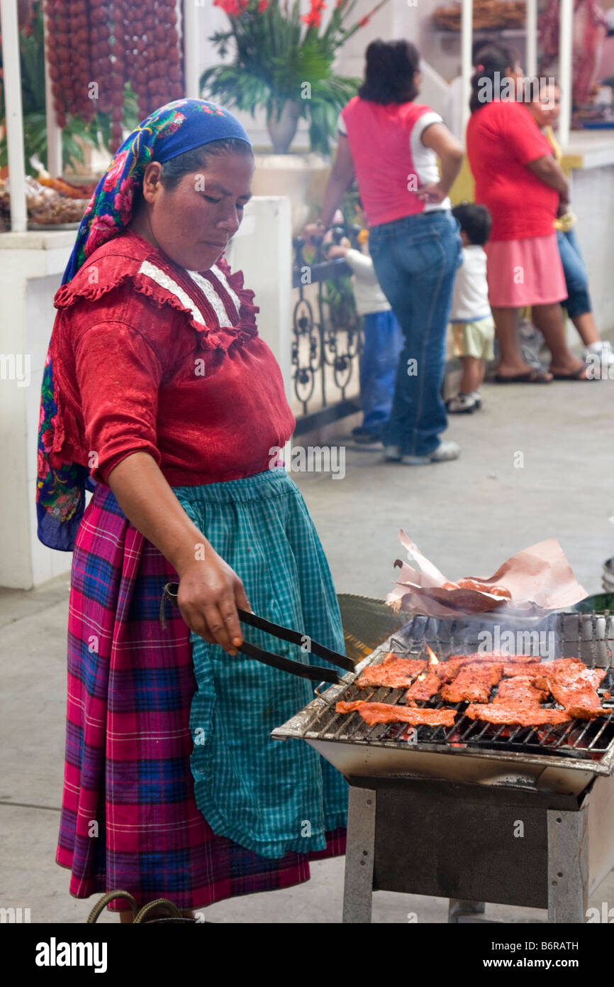Tlacolula, Oaxaca, Mexiko.   Zapoteken Indianerin Kochen von Fleisch zu verkaufen. Stockfoto