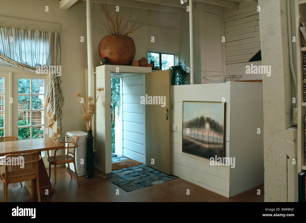 Bild auf niedrige Trennwand im Speisesaal in umgebauten Garage mit Tisch  und Stühlen vor große Fenster Stockfotografie - Alamy