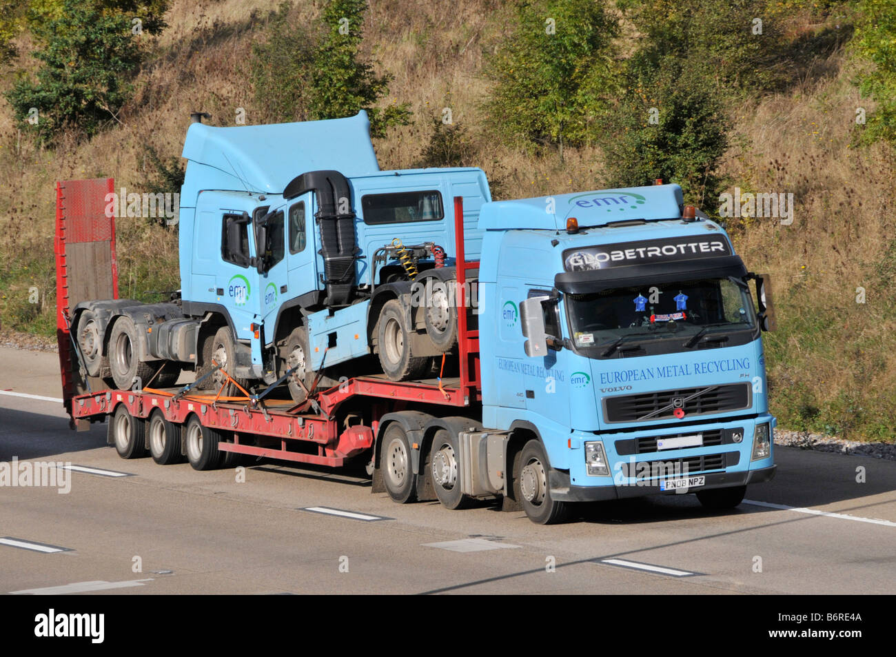 Knickgelenkter LKW-Muldenkipper M25 mit niedrigem Lader und Anhänger, beladen mit zwei ähnlichen Lkw, die entlang der englischen Autobahn M25 Essex England UK fahren Stockfoto Knickgelenkter LKW-Muldenkipper M25 mit niedrigem Lader und Anhänger, beladen mit zwei ähnlichen Lkw, die entlang der englischen Autobahn M25 Essex England UK fahren Stockfoto