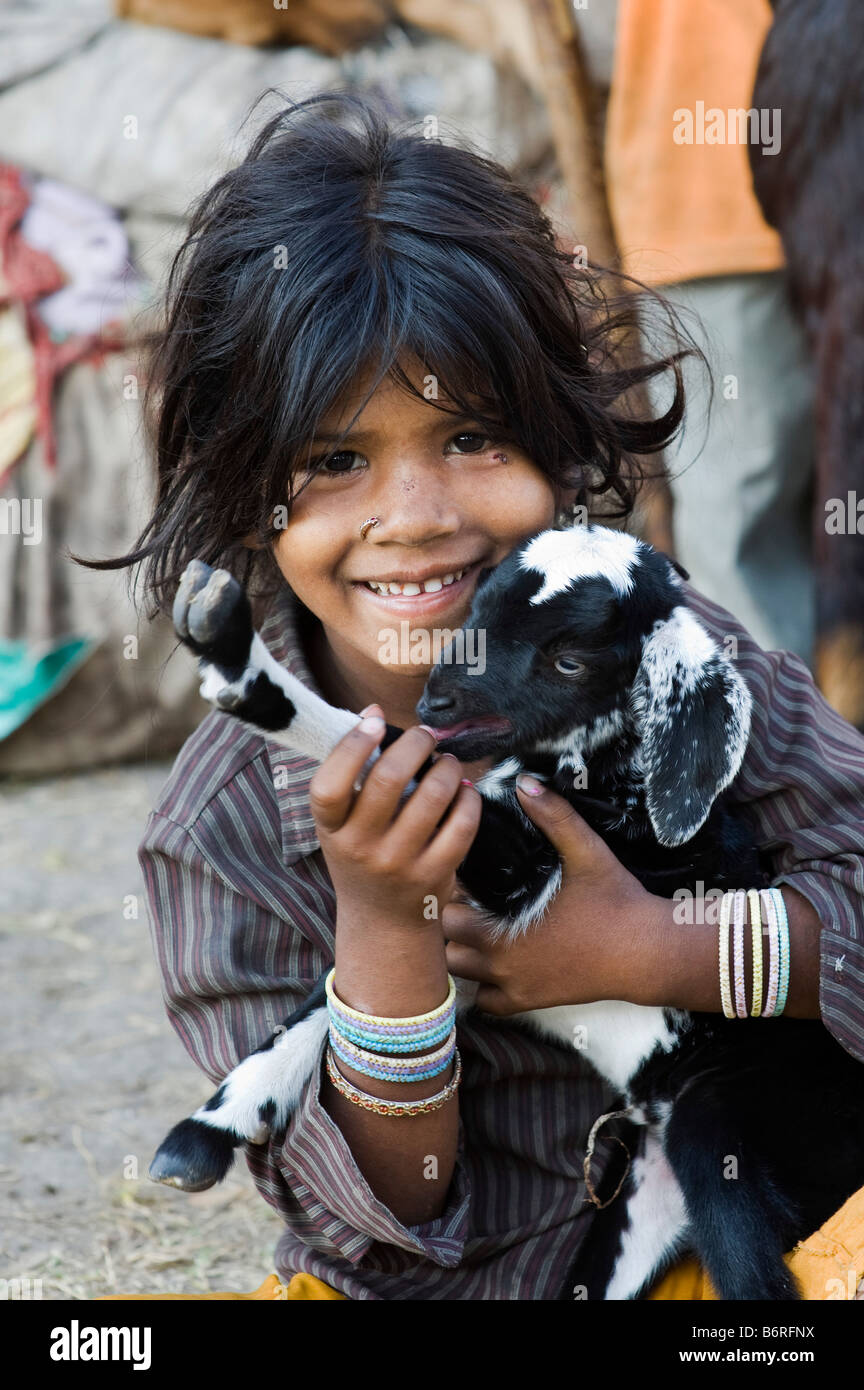 Arme nomadischen indische Mädchen spielen mit einem Baby-Ziege. Andhra Pradesh, Indien Stockfoto